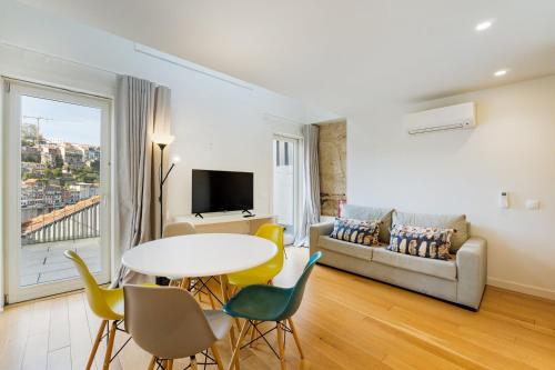 a living room with a table and chairs and a couch at GuestReady - Douro Nest Apartments in Bandeira
