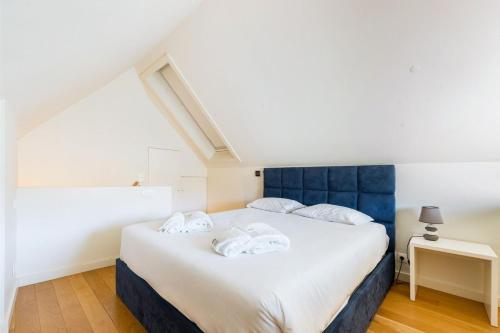 a bedroom with a large white bed with blue headboard at GuestReady - Douro Nest Apartments in Bandeira