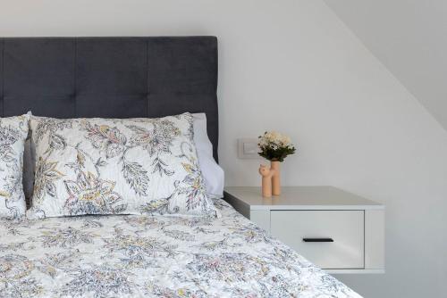 a bedroom with a bed with a black headboard and a night stand at A Casita Do Muelle - Cambados in Cambados