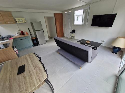 a living room with a couch and a table at Chambres d'hôtes dans Villa à Chateauboeuf in Fort-de-France