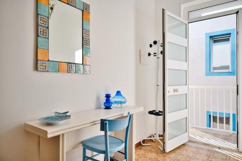 een kamer met een bureau en een blauwe stoel bij Cosentino apartment in Marzamemi