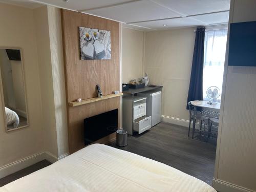 a bedroom with a bed and a desk and a table at Royal Albion Walton in Walton-on-the-Naze
