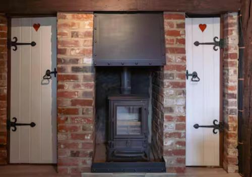 a brick fireplace with a television on top of it at Ye Old Shop Milton by Sheppey Stays in Kent