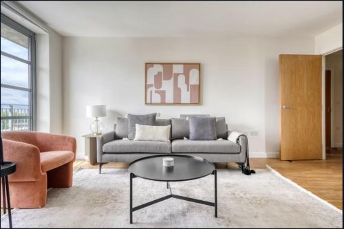 a living room with a couch and a table at Spacious 1-bed Apartment Limehouse Marina in London