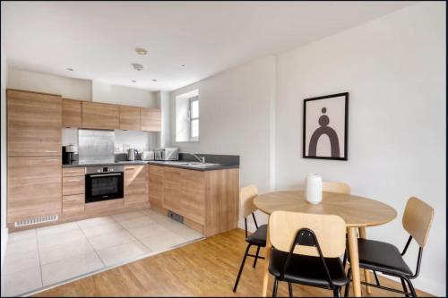 a kitchen and dining room with a table and chairs at Spacious 1-bed Apartment Limehouse Marina in London
