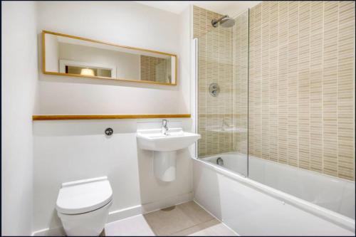 a bathroom with a toilet and a sink and a shower at Spacious 1-bed Apartment Limehouse Marina in London