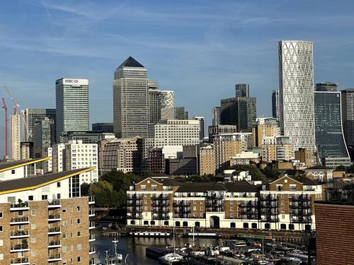 a city skyline with tall buildings and a river at Spacious 1-bed Apartment Limehouse Marina in London