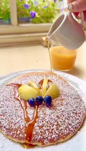 a pancake being drizzled with syrup on a plate at Fitzwilliam Townhouse in Dublin