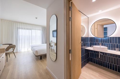 a bathroom with a sink and a mirror at Hotel RH Arena - Todo Incluido in Gandía