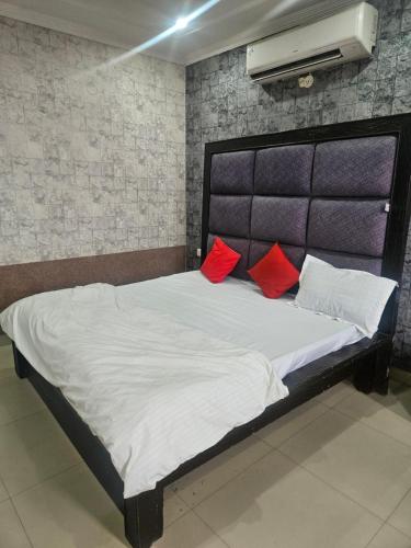 Un dormitorio con una cama con almohadas rojas. en Hotel Amber Palace, en Dehradun