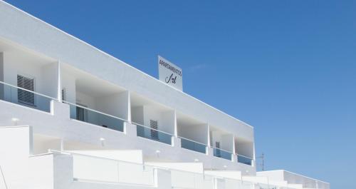 ein weißes Gebäude mit einem Schild an der Seite in der Unterkunft Typic Art in Es Cana