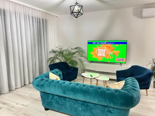 a living room with a blue couch and a tv at Business & Relax House in Jejkowice