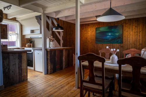 a kitchen with a table and chairs in a room at Statsbuene i Kabelvåg in Kabelvåg