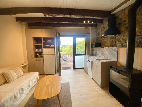 a kitchen with a couch and a table in a room at Country loft Zarautz- San Sebastián in Aia