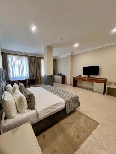 a hotel room with a bed and a flat screen tv at Plaza Viktoria Hotel Yerevan in Yerevan