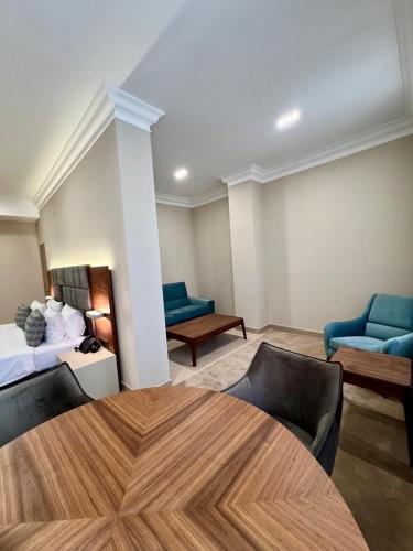 a room with a bed and two chairs and a table at Plaza Viktoria Hotel Yerevan in Yerevan