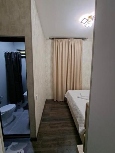 a bathroom with a bed and a sink and a toilet at Old district in Kutaisi