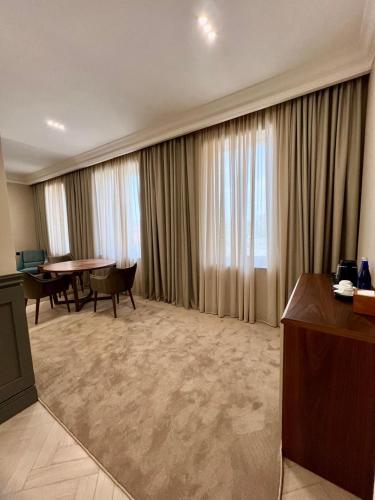 a hotel room with a table and a large window at Plaza Viktoria Hotel Yerevan in Yerevan