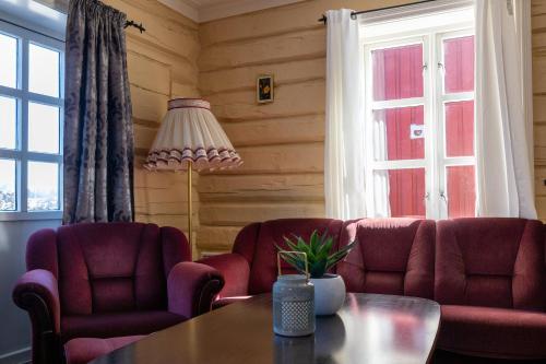 a living room with two chairs and a table at Statsbuene i Kabelvåg in Kabelvåg
