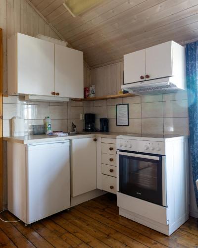 a kitchen with white appliances and white cabinets at Statsbuene i Kabelvåg in Kabelvåg