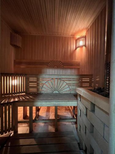 a bench in a room with a wooden wall at Altygat Lodge Barskoon in Barskoon