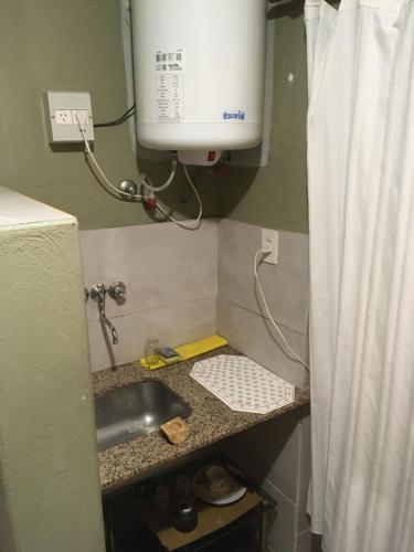a kitchen counter with a sink and a water heater at TERRAZAS DEL SUR in Ezpeleta