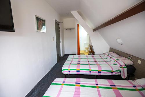 two beds in a small room with a staircase at La Chaumière in Nantes