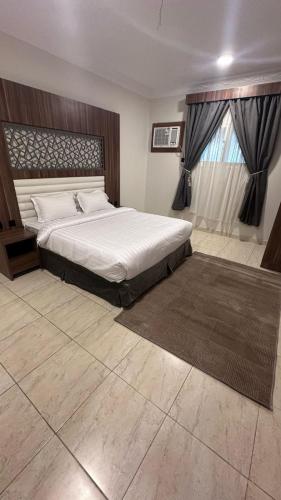a bedroom with a large bed and a window at منازل بريدة للشقق المفروشة in Buraydah