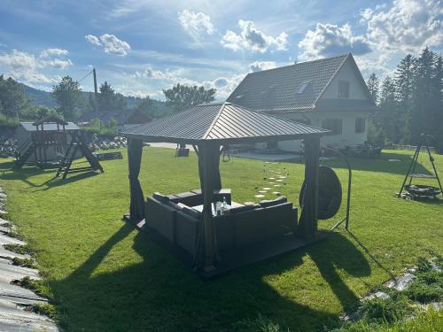 a gazebo with a roof on the grass at Anielski Domek in Nieledwia