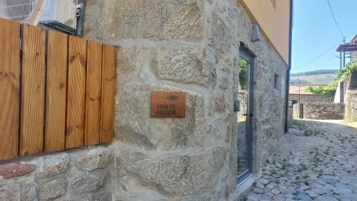 a stone wall with a sign on the side of a building at Green Paradise Glamping in Covas