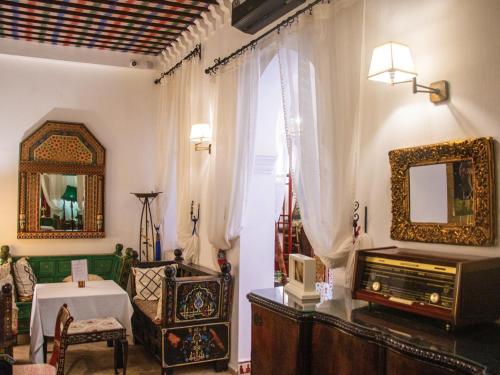 a living room with a television and a mirror at Riad Al-Qurtubi in Tangier