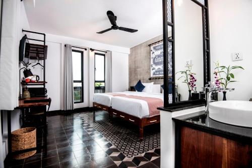 a bedroom with a bed and a sink and a tub at Aquarius Hotel and Urban Resort in Phnom Penh