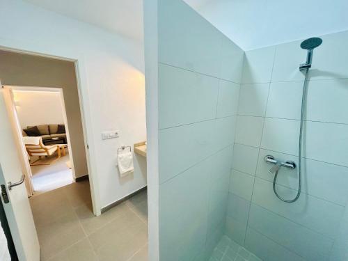 Un baño con ducha con puerta de cristal. en Smart Apartments Facinas, en Facinas