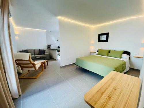 Un dormitorio con una cama, un sofá y una mesa. en Smart Apartments Facinas, en Facinas