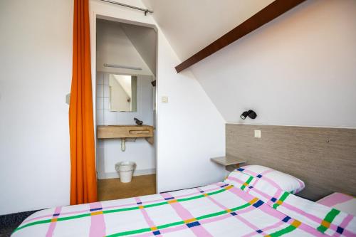 a small bedroom with a bed and a mirror at La Chaumière in Nantes