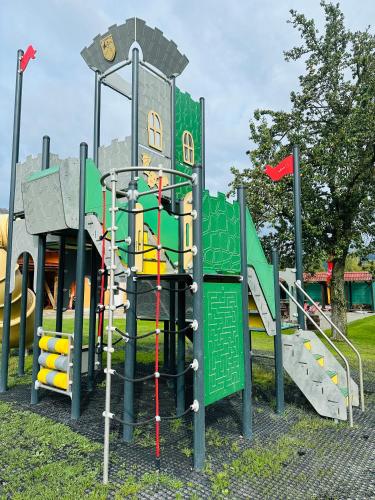 a playground with a green and yellow play equipment at Domčeky na Ranči in Sučany