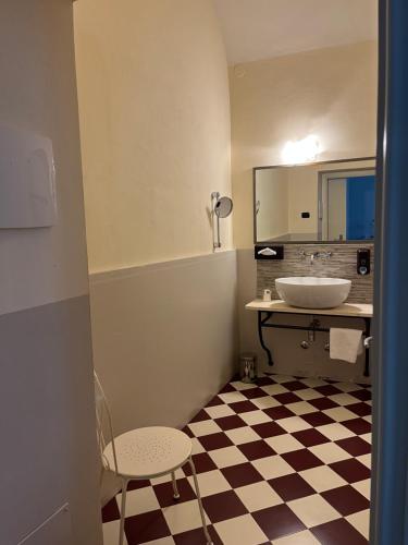 a bathroom with a sink and a checkered floor at Hotel Villa Costanza in Pontenure