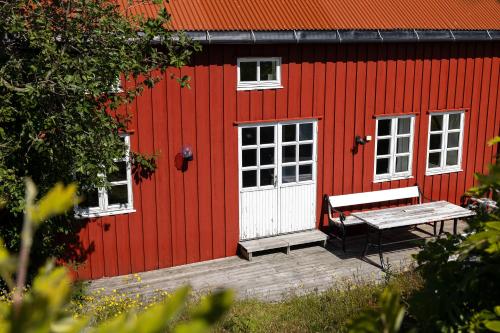 a red building with a bench in front of it at Statsbuene i Kabelvåg in Kabelvåg