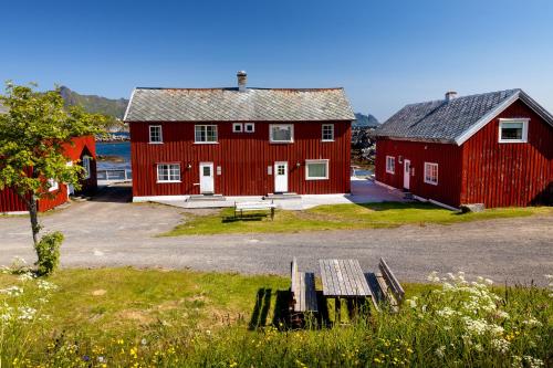 a red barn with a bench in front of it at Statsbuene i Kabelvåg in Kabelvåg