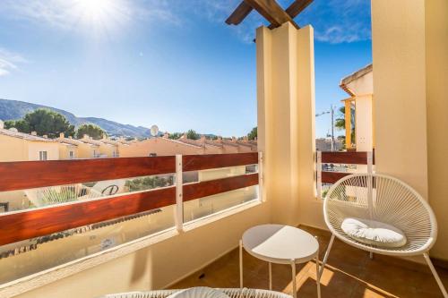 a balcony with two chairs and a large window at Renteando Albir Apartments in Albir
