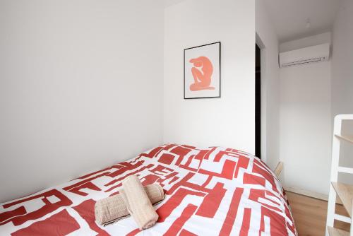 a bedroom with a red and white bed with two towels at Le Nid D'Albi - Studio Duplex - Centre ville CLIM in Albi