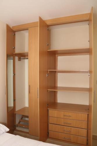 a closet with wooden shelves and a bed at Orchard Homes in Nairobi