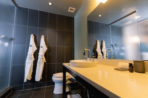 a bathroom with a sink and a toilet and a mirror at The Iron Horse Hotel in Milwaukee