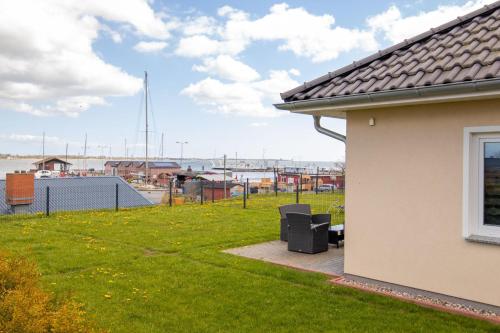 a house with a yard with a view of a harbor at Ferienwohnungen am Hafen in Stahlbrode
