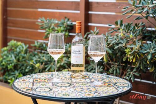 two glasses of white wine sitting on a table at Ta' Guzeppi Boutique Stays by Zzzing in Il-Maħsel