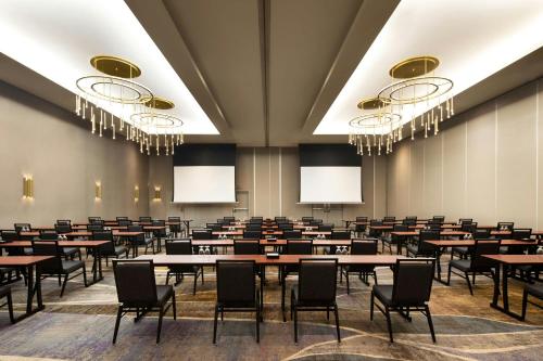a conference room with tables and chairs and chandeliers at Courtyard by Marriott Montreal Airport in Dorval