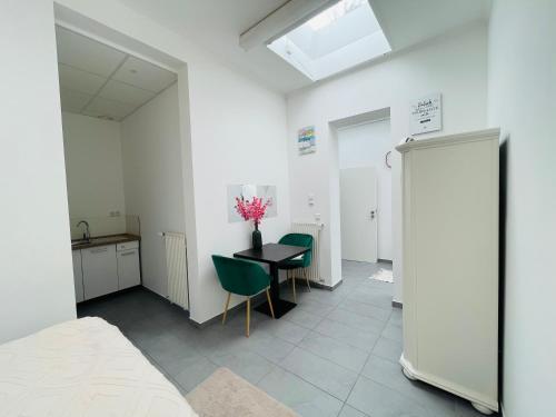 a room with a table and two chairs and a kitchen at Sonnenblume Residenz in Oftersheim