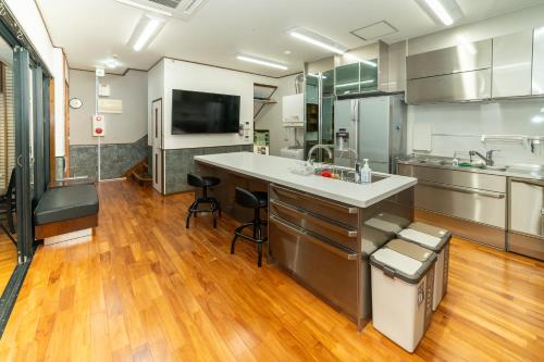 a large kitchen with a sink and a counter at 最大20名宿泊可能 大型テレビでスポーツ観戦 グループ旅行に最適 KOEI HOUSE in AWASE in Okinawa City