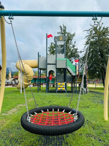 a tire swing in a park with a playground at Domčeky na Ranči in Sučany