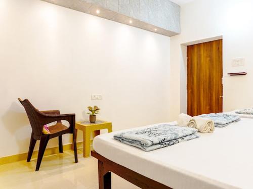 a room with two beds and a chair and a table at Raahee Homestay in Varanasi